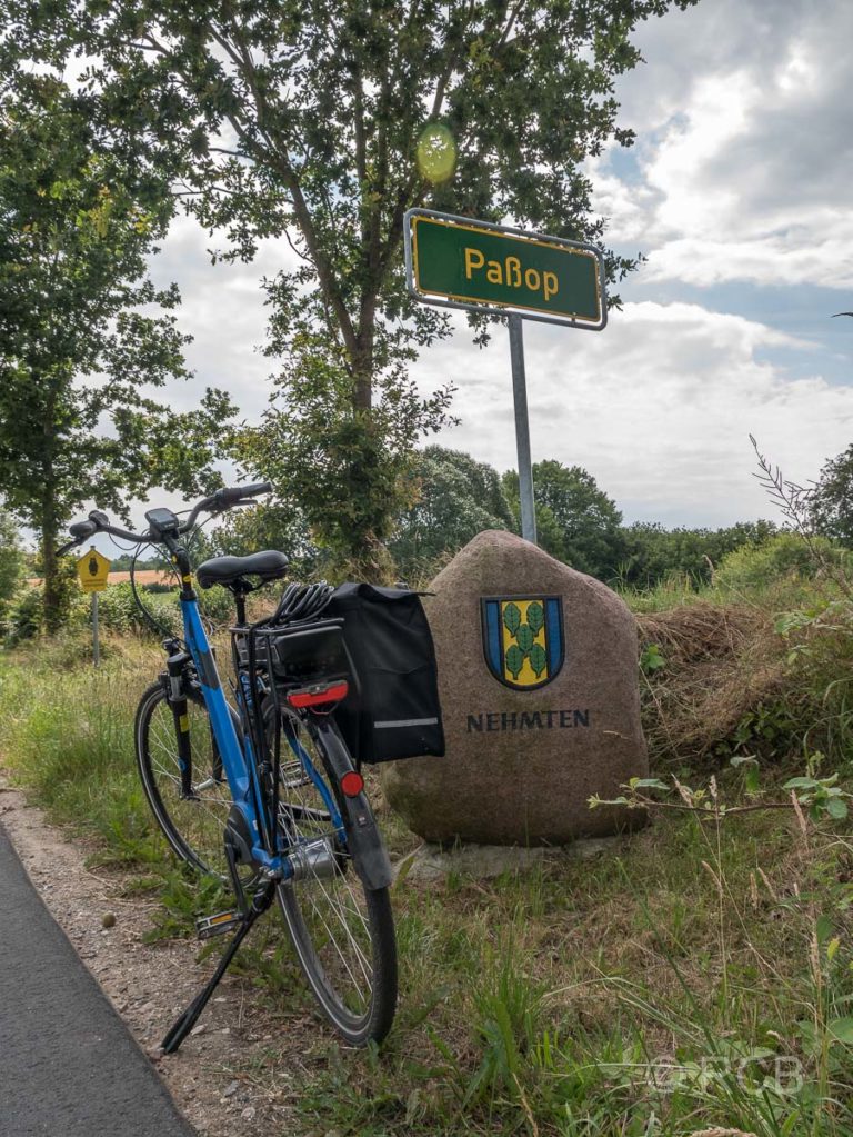 Fahrrad vor dem Ortsschild mit dem Namen "Paßop"