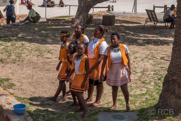 südafrikanische Mädchen singen am Straßenrand in Camps Bay