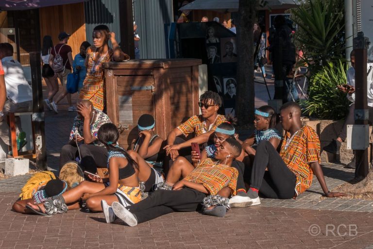 junge Musiker und Tänzer ruhen sich nach einem Auftritt aus an der V&A Waterfront