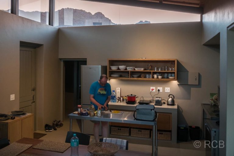 Mann in der Küche eines Ferienhauses, Kromrivier