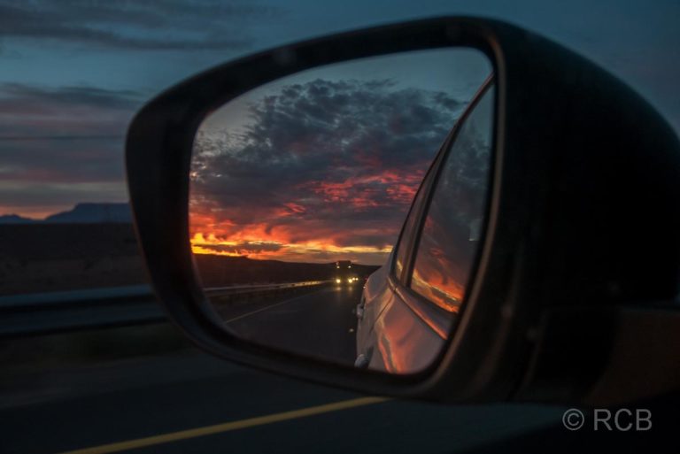 Sonnenuntergang im Seitenspiegel eines Autos