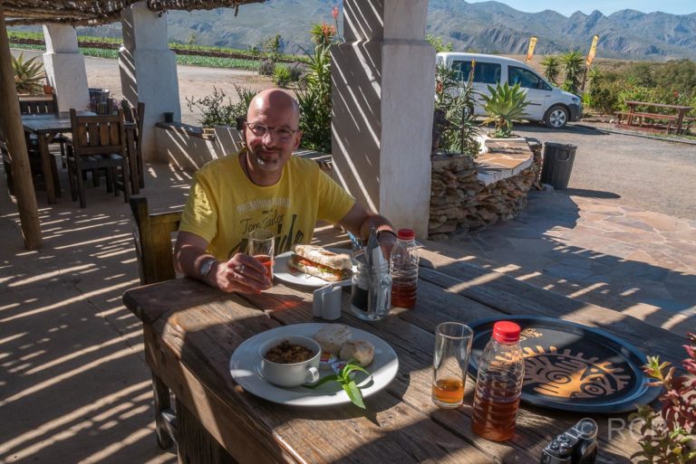 Mann vor seinem Essen im Lokal "Kobus Se Gat" am Swartberg Pass