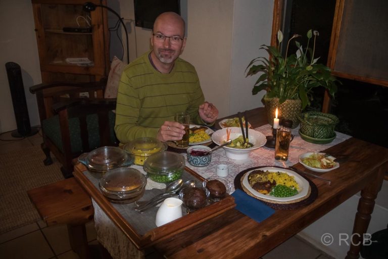 Mann beim Abendessen mit der südafrikanischen Spezialität Bobotie, Potteberg Guest Farm