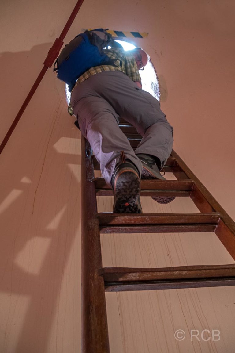 Mann klettert auf einer Leiter hoch im Leuchtturm am Cape Agulhas