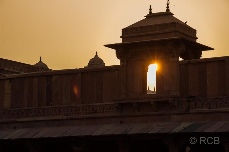 Fatehpur Sikri, die untergehende Sonne scheint unter einer Kuppel hindurch