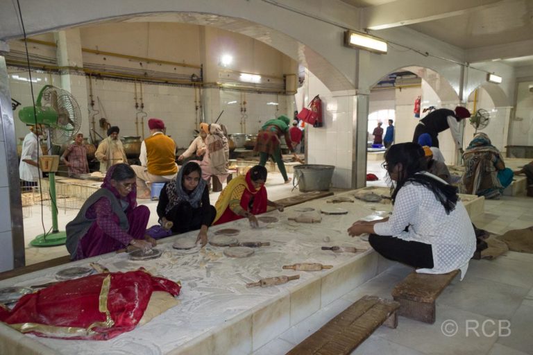 Frauen formen Fladenbrote bei den Vorbereitungen für die Speisung im Sikh-Tempel Bangla Sahib Gurudwara, Delhi