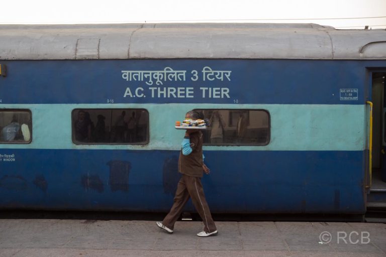 Agra, Kellner geht an einem Zug vorbei im Bahnhof Cantonment