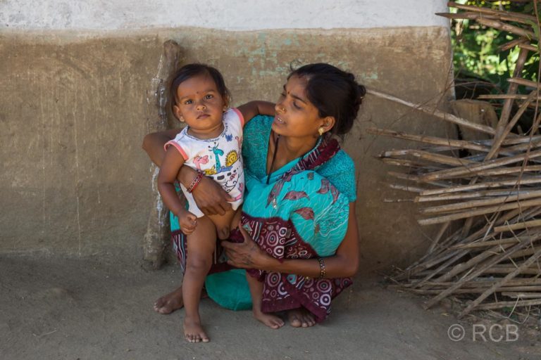 Mutter mit Kind in einem Dorf in der Nähe des Kanha National Park