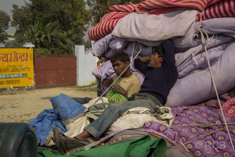 Männer ruhen sich aus auf Decken auf der Pritsche eines LKW , Fahrt durch Uttar Pradesh