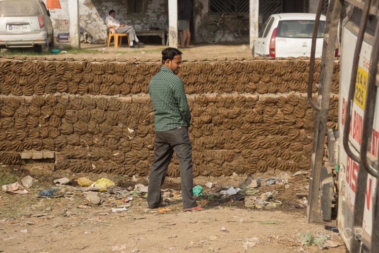 Fahrt durch Uttar Pradesh, Mann uriniert am Straßenrand