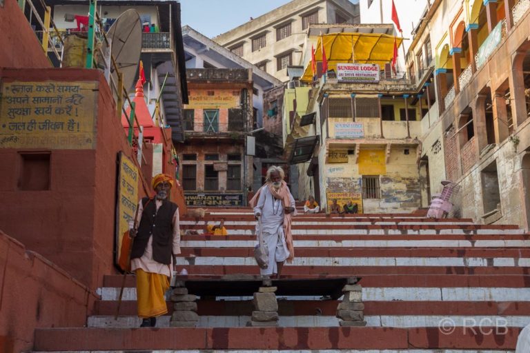 Varanasi, Sadhus steigen an den Ghats eine Treppe hinunter