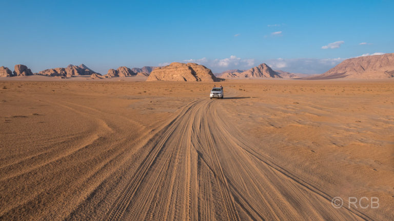 Jeepspuren und Jeep im Wadi Rum