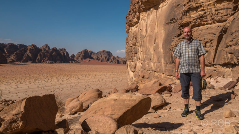 Mann steht auf einem Felsplateau im Wadi Rum