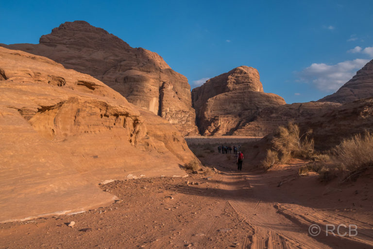 Wanderer bei Abendsonne in einer Felspassage im Wadi Rum