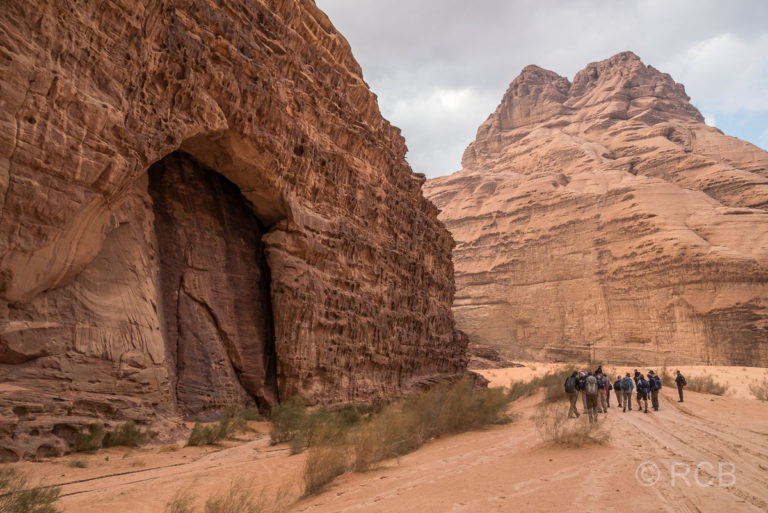 Wanderer neben einem Felseinschnitt im Wadi Rum
