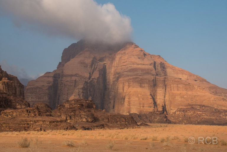 eine Wolke hängt an einem Felsen im Wadi Rum fest