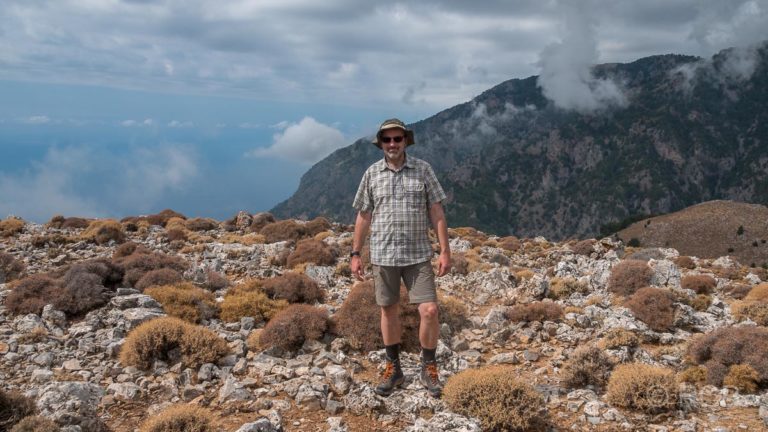Mann steht am Gipfel des Papouras