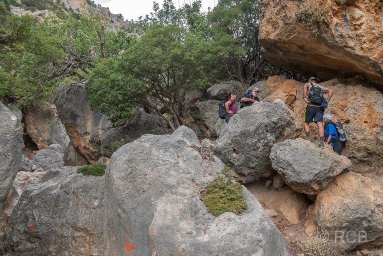 Wanderer klettern über Felsen in der Anidri-Schlucht