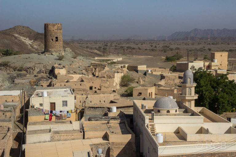 Blick von einem Wehrturm auf alte und neue Häuser in Al Mudayrib