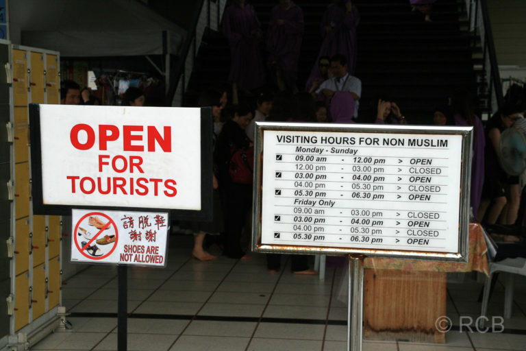 Schilder mit den Öffnungszeiten für Touristen am Kuala Lumpur