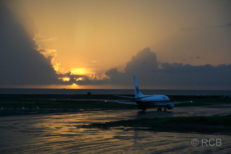 Rollfeld am Flughafen Kota Kinabalu mit einem Flugzeug im Sonnenuntergang