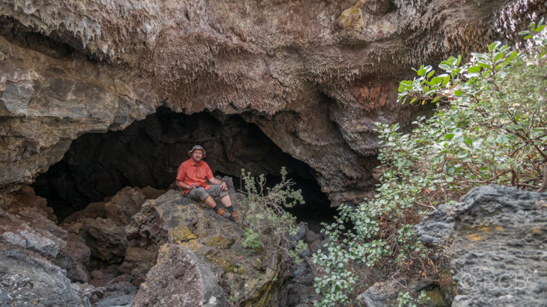 Wanderer vor einer Höhle im Lavastrom des Vulkans San Juan
