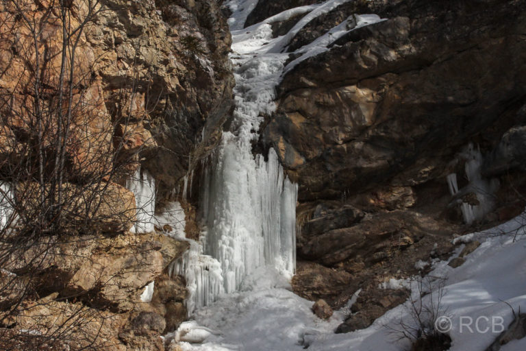 gefrorener Wasserfall am Wegrand