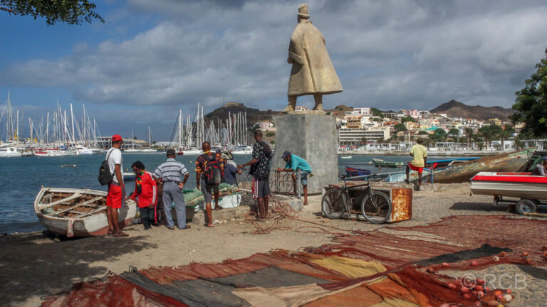 Fischer an der Bronzestatue des portugisischen Seefahrers Diogo Alfonso