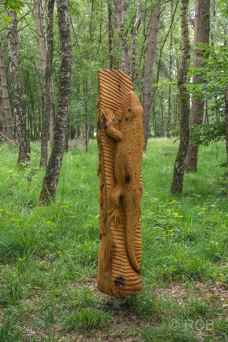 Skulptur eines Lurches im Wald
