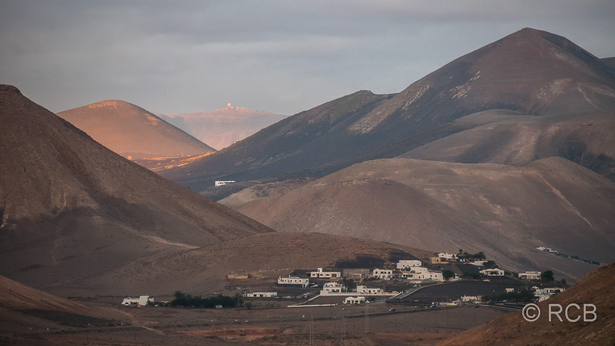 Blick über das Ajaches-Gebirge und La Geria bis hin zur Militärstation auf dem Gipfel des Peñas del Chache