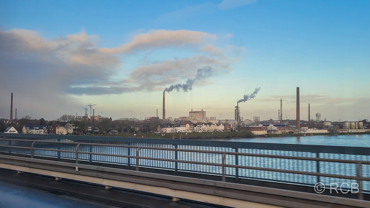 Blick von der Rheinbrücke der A40 auf Homberg-Essenberg und das Chemiewerk