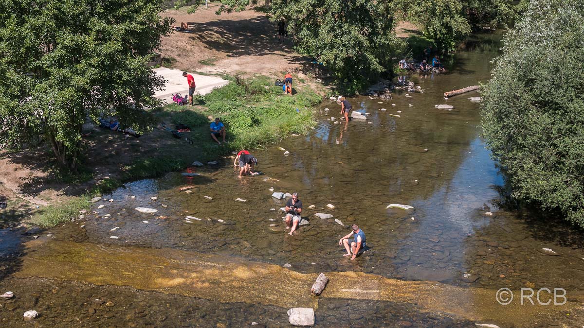 Pilger baden ihre Füße im Fluss