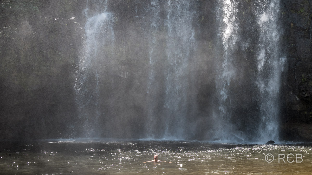 Mann unter einem Wasserfall