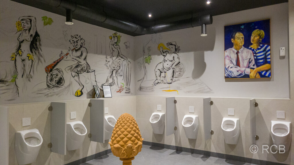 Pissoirs in Herrentoilette mit Kunstwerken darüber