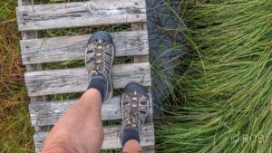 Schuhe eines Wanderers auf einem Bohlenweg, darunter Wasser