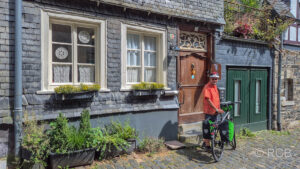 Radfahrer vor schieferverkleidetem Haus